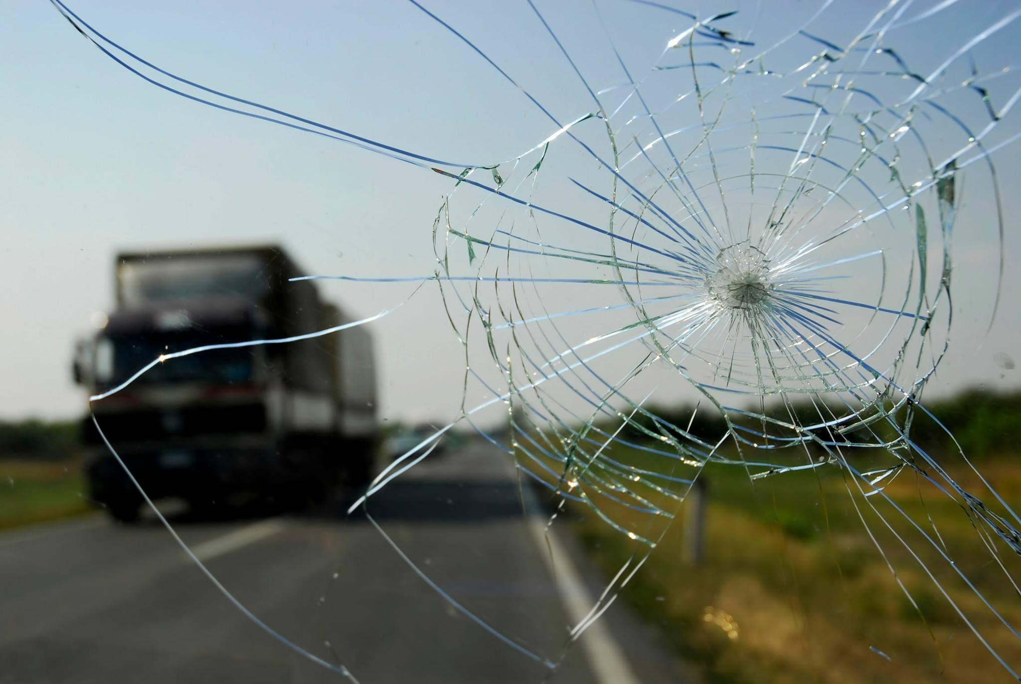 Star chip windshield damage with truck ahead on Grand Junction roadway.
